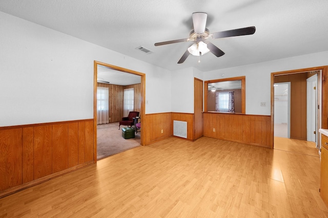 104 W Oak St, Yantis, TX 75497 - empty room with a wainscoted wall, wood finished floors, ceiling fan, and wooden walls