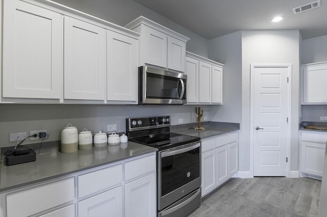 704 Griffith Park Trl, Alvarado, TX 76009 - kitchen with stainless steel appliances, white cabinetry, light wood-type flooring, recessed lighting, and baseboards