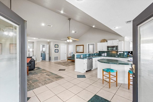 970 Gulfview Dr, Crystal Beach, TX 77650 - kitchen featuring appliances with stainless steel finishes, a peninsula, white cabinetry, vaulted ceiling, and open floor plan
