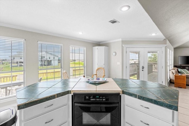 970 Gulfview Dr, Crystal Beach, TX 77650 - kitchen featuring oven, crown molding, french doors, dark countertops, and white cabinetry