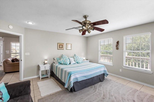 970 Gulfview Dr, Crystal Beach, TX 77650 - tiled bedroom with ceiling fan, baseboards, and a textured ceiling