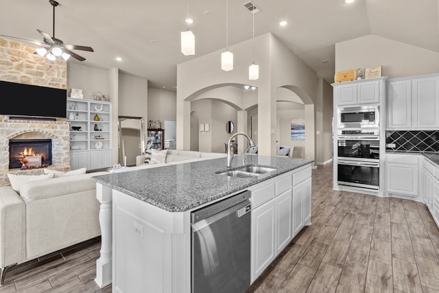 9212 Brittlebrush Trl, Fort Worth, TX 76177 - kitchen with appliances with stainless steel finishes, a sink, open floor plan, arched walkways, and recessed lighting