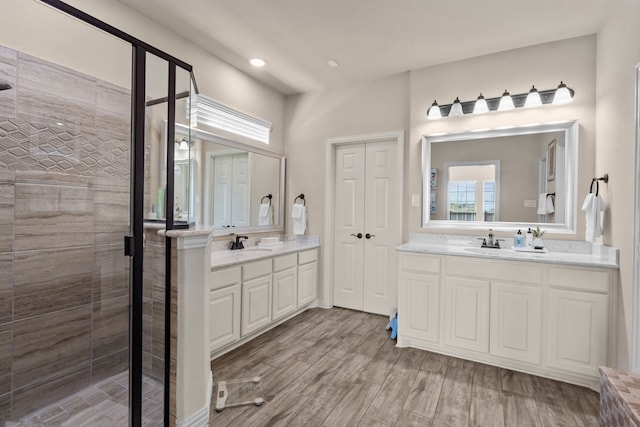 9212 Brittlebrush Trl, Fort Worth, TX 76177 - bathroom with a stall shower, two vanities, wood finished floors, and recessed lighting