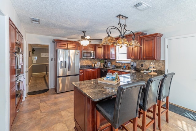 1501 Raintree Ct, Grand Prairie, TX 75050 - kitchen with appliances with stainless steel finishes, a peninsula, backsplash, a kitchen bar, and baseboards