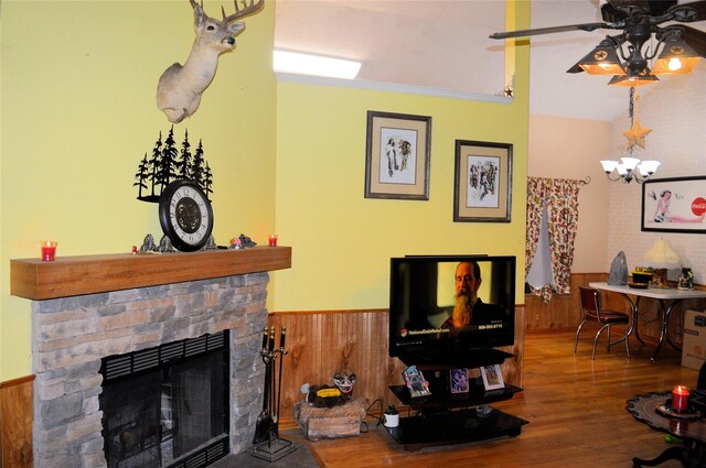 8109 Camelot Rd, Fort Worth, TX 76134 - living area with a wainscoted wall, wood finished floors, a fireplace, a ceiling fan, and wood walls