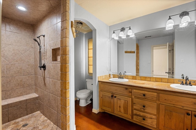 1511 Cabaniss Ln, Weatherford, TX 76088 - bathroom featuring toilet, double vanity, tiled shower, and recessed lighting