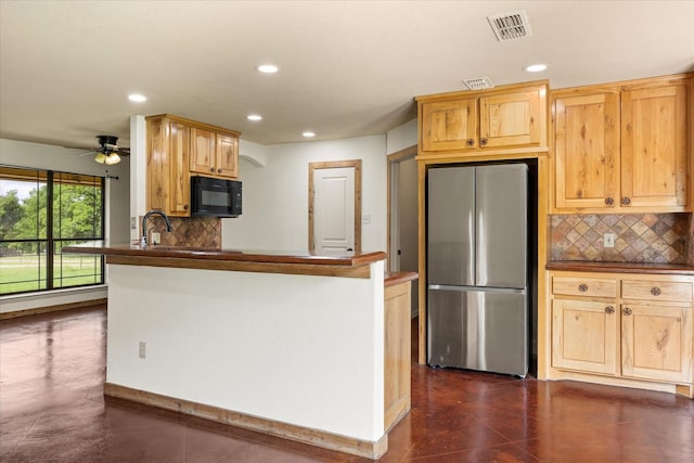 1511 Cabaniss Ln, Weatherford, TX 76088 - kitchen featuring freestanding refrigerator, black microwave, recessed lighting, dark countertops, and backsplash