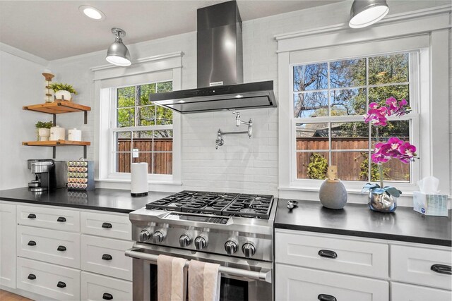 435 Allison Dr, Dallas, TX 75208 - kitchen featuring stainless steel stove, wall chimney exhaust hood, dark countertops, decorative backsplash, and crown molding