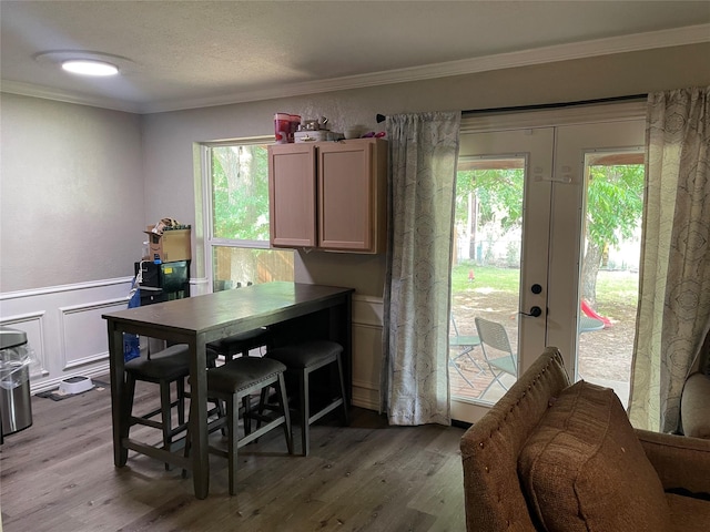 322 Cherry St, Weatherford, TX 76086 - dining room with crown molding, light wood-style floors, french doors, a wainscoted wall, and a decorative wall