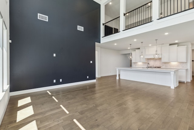 16431 Elk Hollow Rd, Frisco, TX 75035 - unfurnished living room with baseboards, a towering ceiling, wood finished floors, and recessed lighting