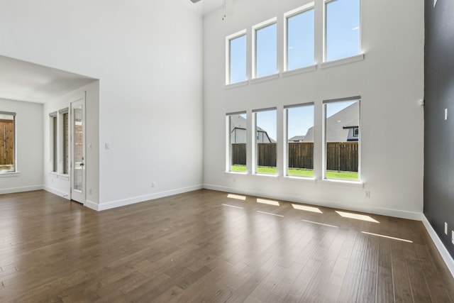 16431 Elk Hollow Rd, Frisco, TX 75035 - empty room featuring a high ceiling, plenty of natural light, baseboards, and dark wood-style flooring