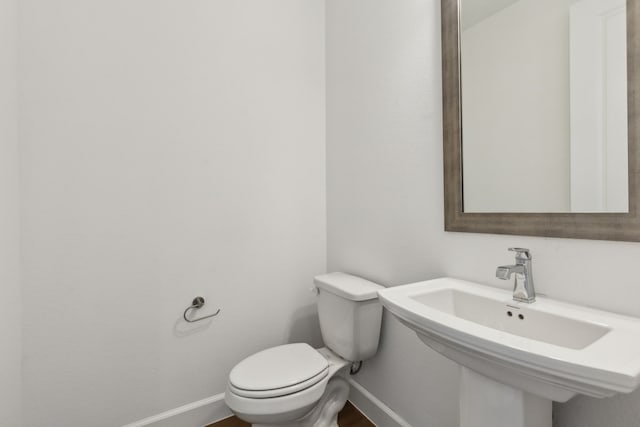 16431 Elk Hollow Rd, Frisco, TX 75035 - half bathroom with baseboards, toilet, a sink, and wood finished floors