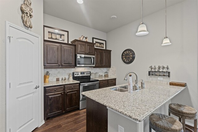 2101 Swenson Ranch Trl, Fort Worth, TX 76134 - kitchen featuring stainless steel appliances, a sink, a kitchen bar, backsplash, and dark brown cabinetry