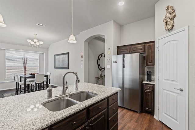 2101 Swenson Ranch Trl, Fort Worth, TX 76134 - kitchen featuring freestanding refrigerator, a sink, arched walkways, dark brown cabinets, and dark wood finished floors