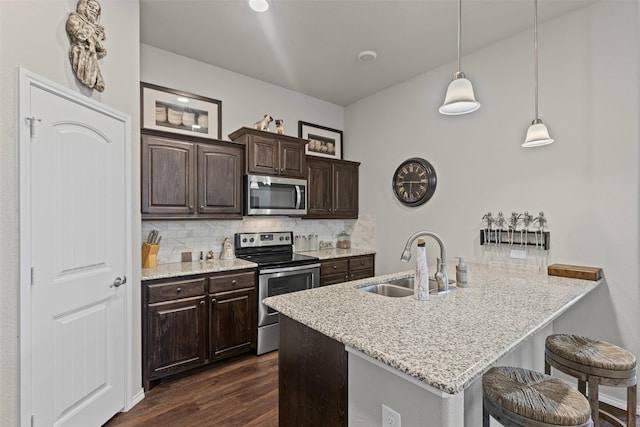 2101 Swenson Ranch Trl, Fort Worth, TX 76134 - kitchen with stainless steel appliances, a sink, a kitchen breakfast bar, tasteful backsplash, and dark brown cabinets