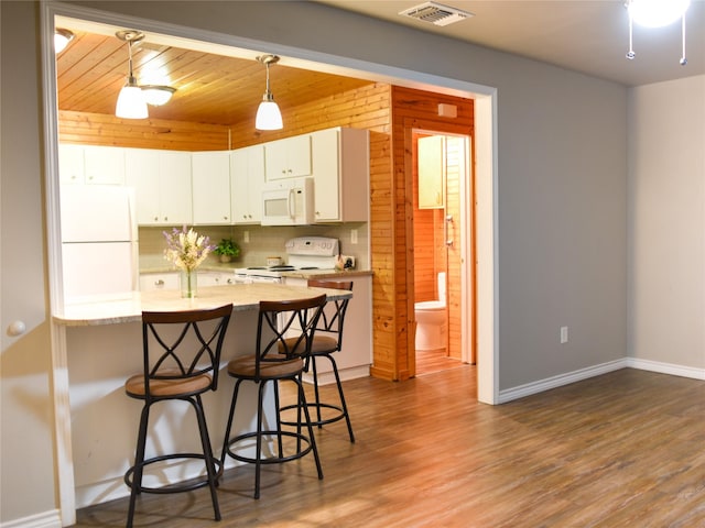 2226 Bethany Rd, Sherman, TX 75090 - kitchen featuring white appliances, a breakfast bar, wood finished floors, baseboards, and white cabinets