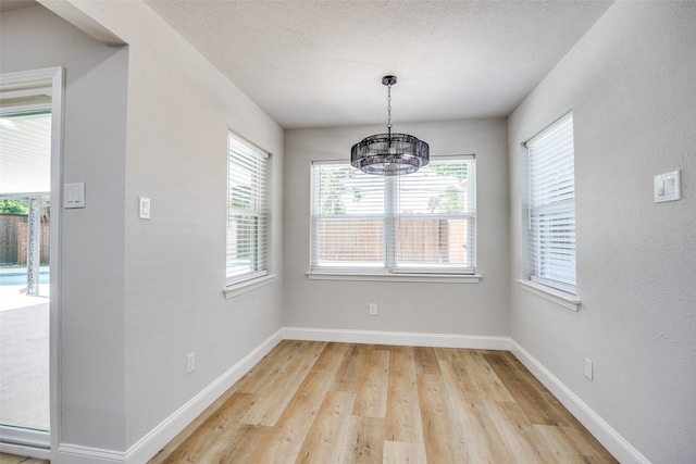 3414 Janlyn Ln, Farmers Branch, TX 75234 - unfurnished dining area featuring a chandelier, light wood-style flooring, and baseboards