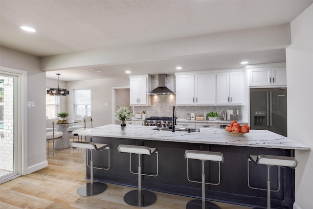 3414 Janlyn Ln, Farmers Branch, TX 75234 - kitchen with wall chimney range hood, black fridge, white cabinetry, a sink, and decorative backsplash