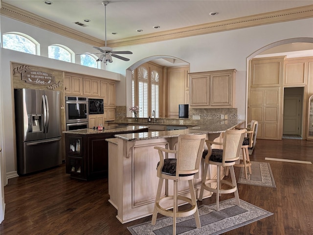 5812 Braemar Dr, Plano, TX 75093 - kitchen featuring stainless steel appliances, light stone counters, decorative backsplash, arched walkways, and crown molding