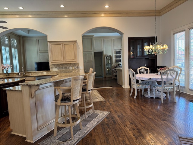 5812 Braemar Dr, Plano, TX 75093 - kitchen featuring a sink, light stone countertops, a breakfast bar, dark wood finished floors, and crown molding