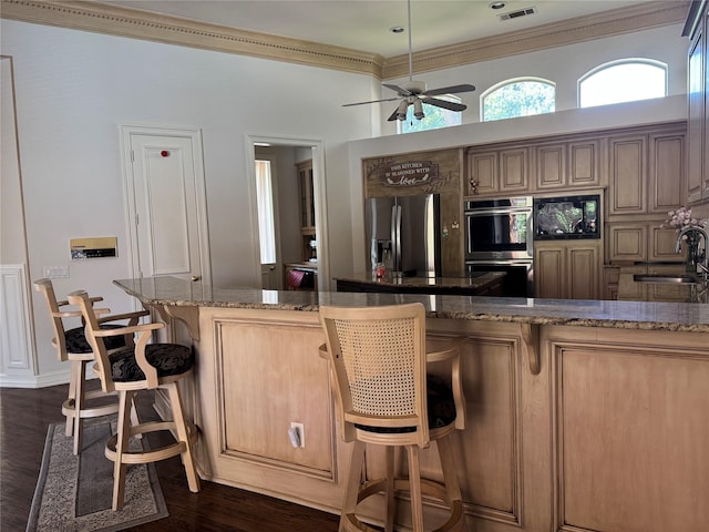 5812 Braemar Dr, Plano, TX 75093 - kitchen featuring stainless steel appliances, a sink, ornamental molding, dark wood-style flooring, and a kitchen bar