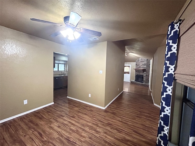 10058 Marblehead Ct, Fort Worth, TX 76108 - empty room featuring a fireplace, a sink, a ceiling fan, dark wood-style floors, and baseboards