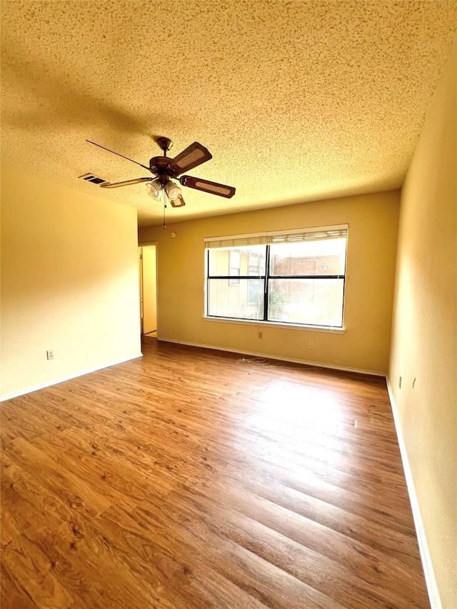 2617 Independence Dr, Mesquite, TX 75150 - empty room with a textured ceiling, wood finished floors, ceiling fan, and baseboards