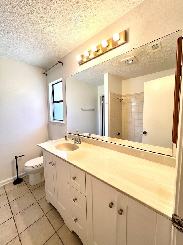2617 Independence Dr, Mesquite, TX 75150 - bathroom with a textured ceiling, toilet, double vanity, tile patterned flooring, and tiled shower
