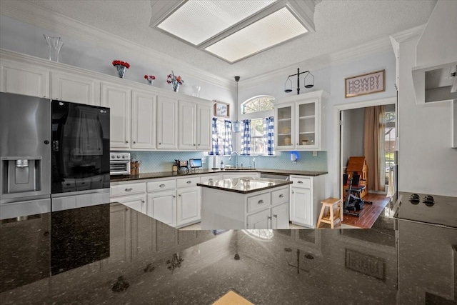 9505 Lost Trails Dr, Waco, TX 76712 - kitchen with backsplash, white cabinets, ornamental molding, glass insert cabinets, and refrigerator with ice dispenser