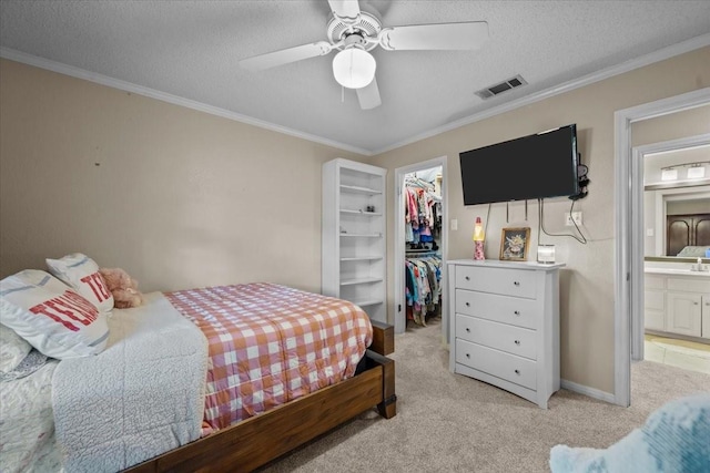 9505 Lost Trails Dr, Waco, TX 76712 - bedroom with a walk in closet, light colored carpet, a closet, crown molding, and a textured ceiling