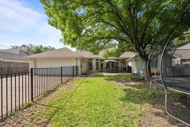 9505 Lost Trails Dr, Waco, TX 76712 - view of yard featuring a trampoline, a garage, driveway, and a patio area