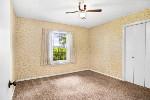 880 S Fm 779, Emory, TX 75440 - unfurnished bedroom featuring carpet floors, a closet, a ceiling fan, a textured ceiling, and wallpapered walls