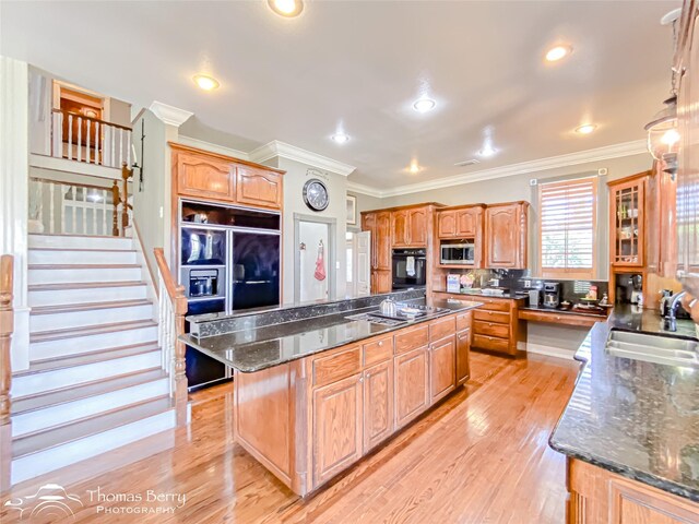 3226 County Road 360, Merkel, TX 79536 - kitchen with oven, stainless steel microwave, a sink, a center island, and ornamental molding
