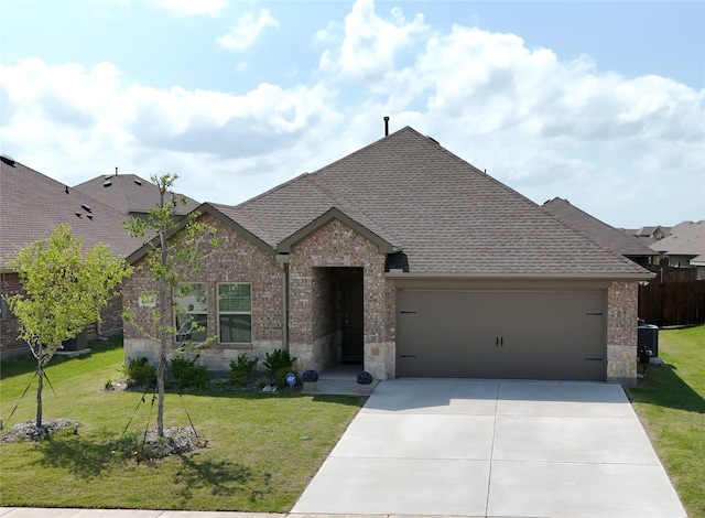 1416 Blossom Court Dr, Princeton, TX 75407 - view of front of house featuring a shingled roof, an attached garage, brick siding, concrete driveway, and stone siding