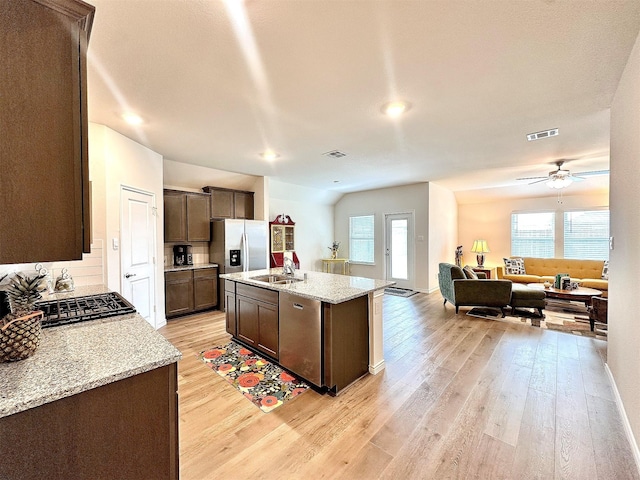 1416 Blossom Court Dr, Princeton, TX 75407 - kitchen featuring stainless steel appliances, a sink, open floor plan, light wood finished floors, and dark brown cabinets