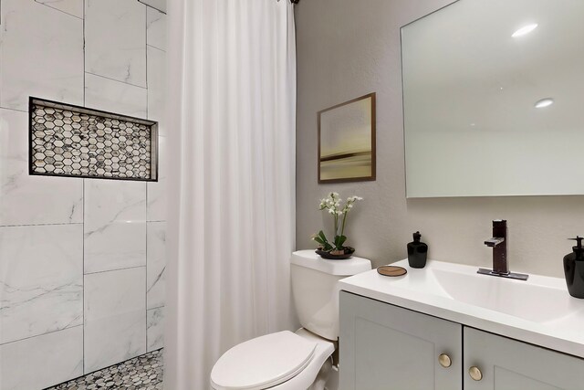 9726 Cushing Dr, Dallas, TX 75217 - full bathroom with toilet, vanity, and a tile shower