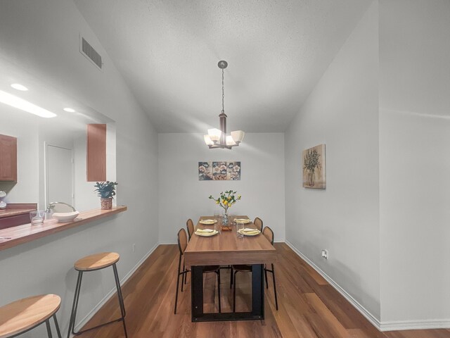 1215 Keechi St, Weatherford, TX 76086 - dining area with vaulted ceiling, a chandelier, dark wood-style flooring, and baseboards