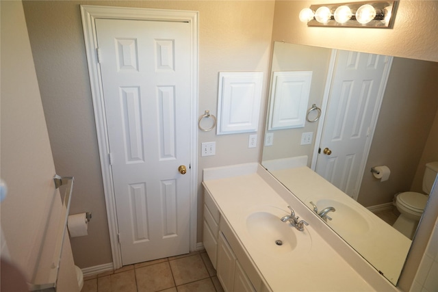 8300 Charleston St, Irving, TX 75063 - bathroom featuring toilet, vanity, tile patterned floors, and baseboards