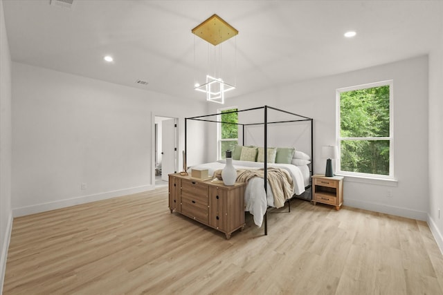 1336 Compton St, Dallas, TX 75203 - bedroom with light wood-style flooring, baseboards, recessed lighting, and a chandelier