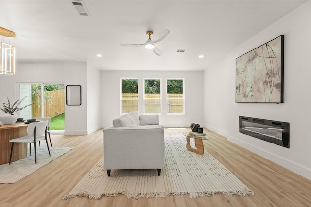 1336 Compton St, Dallas, TX 75203 - living area featuring baseboards, light wood finished floors, ceiling fan, recessed lighting, and a glass covered fireplace