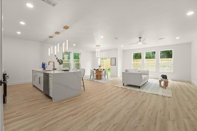 1336 Compton St, Dallas, TX 75203 - kitchen with stainless steel dishwasher, light wood finished floors, a sink, recessed lighting, and hanging light fixtures