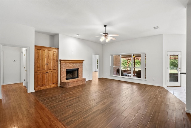10208 W Rancho Diego Ln, Fort Worth, TX 76036 - unfurnished living room featuring dark wood-style flooring, ceiling fan, a fireplace, and baseboards