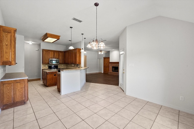 10208 W Rancho Diego Ln, Fort Worth, TX 76036 - kitchen featuring appliances with stainless steel finishes, open floor plan, a chandelier, a peninsula, and a brick fireplace