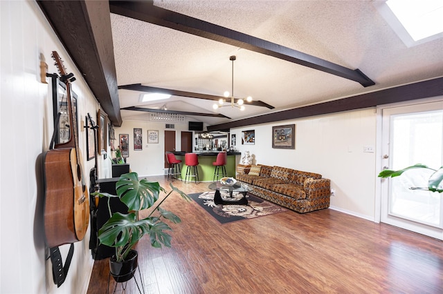 4458 Cardiff Ave, Fort Worth, TX 76133 - living area featuring wood finished floors, a chandelier, a textured ceiling, baseboards, and a skylight