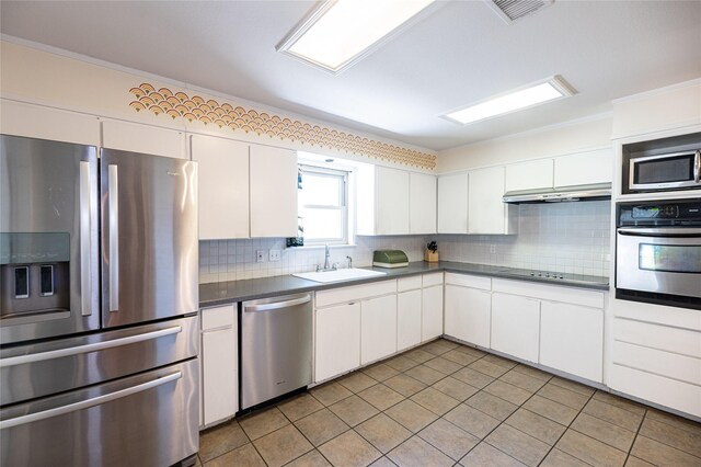 4458 Cardiff Ave, Fort Worth, TX 76133 - kitchen with appliances with stainless steel finishes, a sink, dark countertops, and backsplash