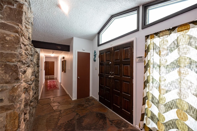 4458 Cardiff Ave, Fort Worth, TX 76133 - entryway with a textured ceiling, stone floors, and high vaulted ceiling