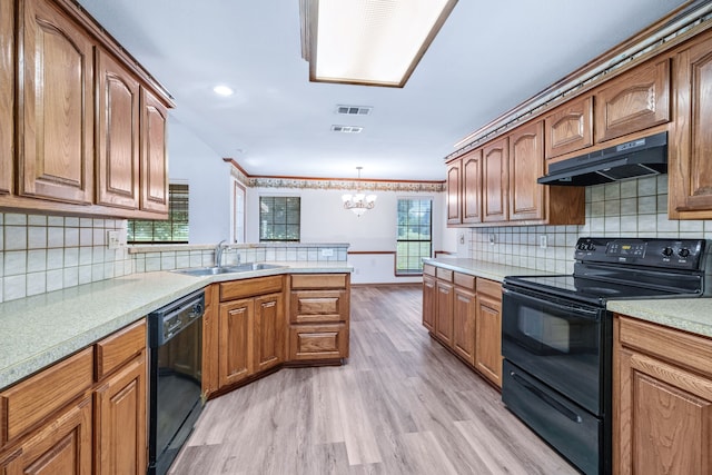 5282 Homeplace Ln, Kaufman, TX 75142 - kitchen featuring black appliances, under cabinet range hood, a sink, a chandelier, and light wood-type flooring