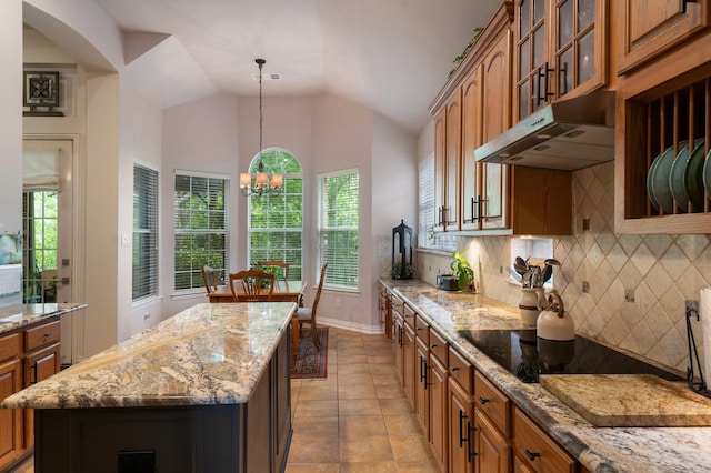 1869 Rio Blanco Dr, Frisco, TX 75033 - kitchen with brown cabinets, decorative backsplash, glass insert cabinets, light stone countertops, and light tile patterned floors