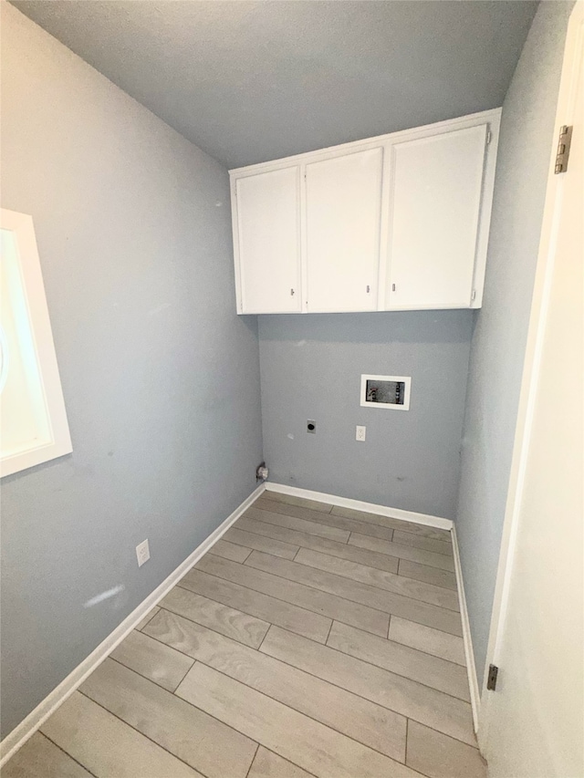 1111 Joel St, Groesbeck, TX 76642 - laundry area with washer hookup, electric dryer hookup, light wood-style floors, and cabinet space