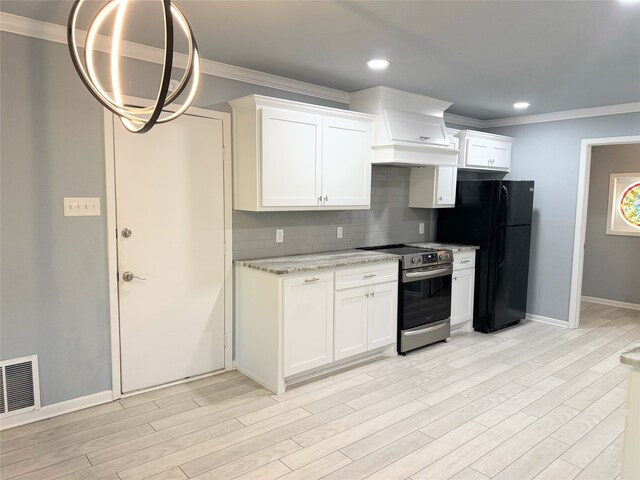 1111 Joel St, Groesbeck, TX 76642 - kitchen with stainless steel electric range oven, freestanding refrigerator, crown molding, tasteful backsplash, and light wood finished floors